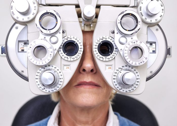 Senior woman patient, eye test and phoropter in hospital, optometrist office or clinic for vision h.